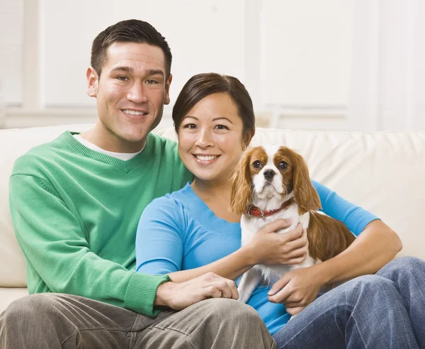 Atraente asiático casal segurando cão Fotos De Bancos De Imagens