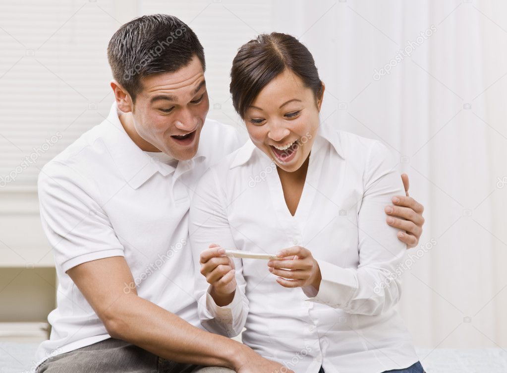 Ecstatic Couple Looking at a Pregnancy Test Together.