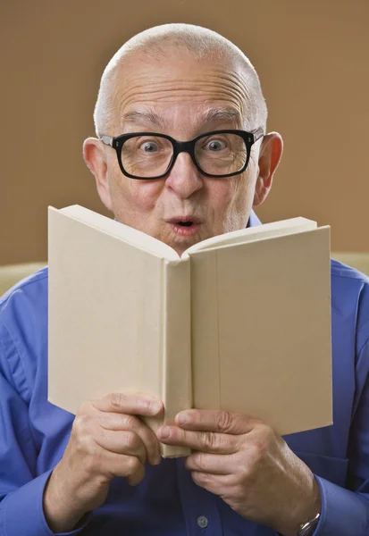 Silly senior man reading book. — Stock Photo, Image
