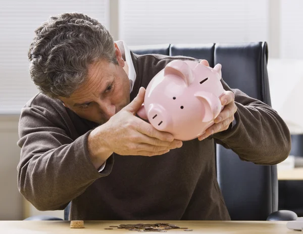 Homme regardant Piggy Bank — Photo