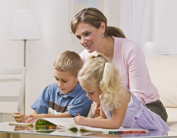 Женщина сидит с детьми
