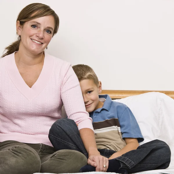 Madre e figlio seduta sul letto — Foto Stock