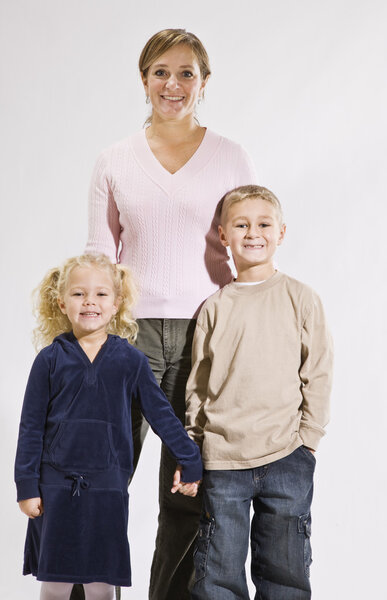 Женщина и дети улыбаются перед камерой
