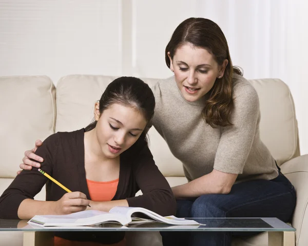 Donna aiutare figlia con i compiti — Foto Stock