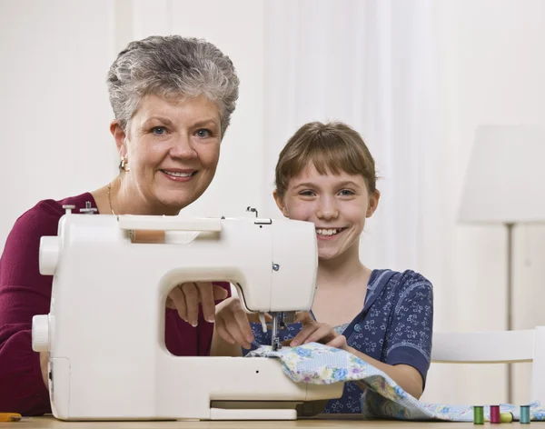 Grandaughter naaien met kleindochter — Stockfoto