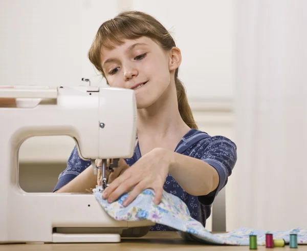 Menina na máquina de costura — Fotografia de Stock