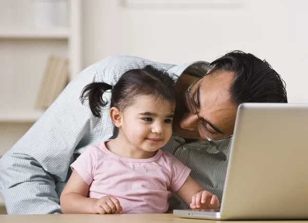 Far och dotter spelar på datorn — Stockfoto