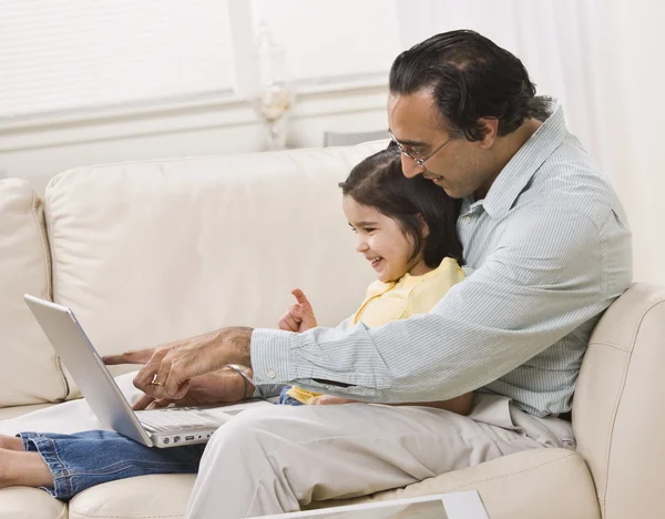 Vater und Tochter schauen gemeinsam auf Laptop — Stockfoto