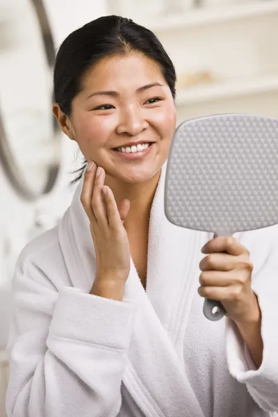 Donna sorridente guardando nello specchio — Foto Stock