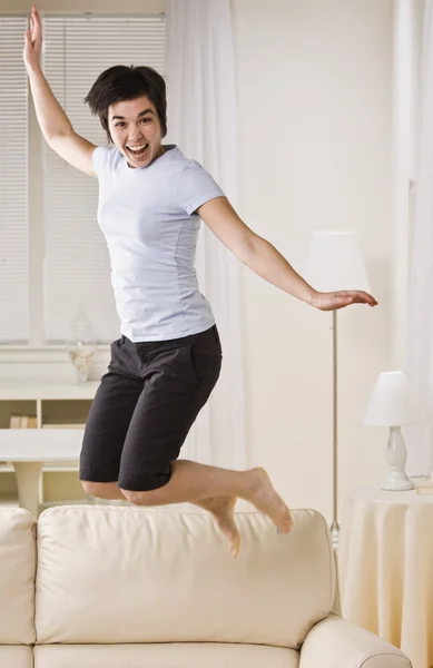 Mulher pulando no sofá — Fotografia de Stock