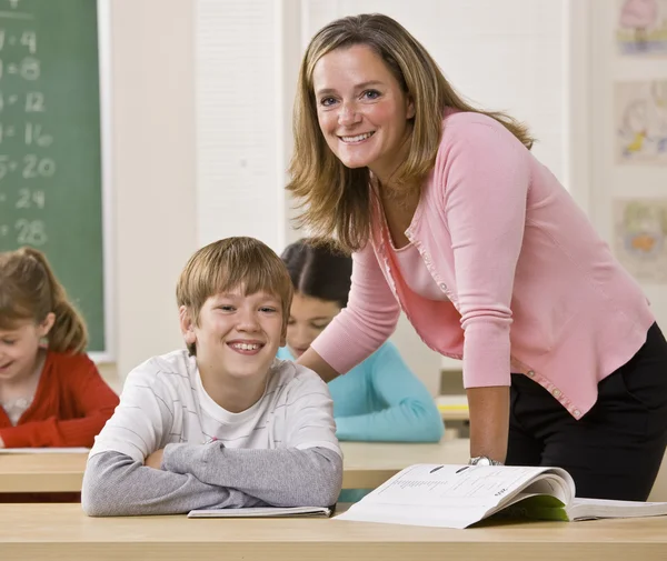 Läraren hjälper eleven i klassrummet — Stockfoto