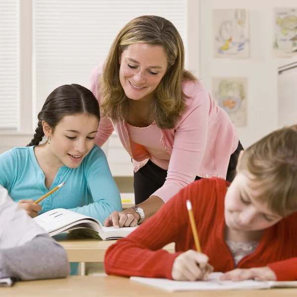 Läraren hjälper eleven i klassrummet — Stockfoto