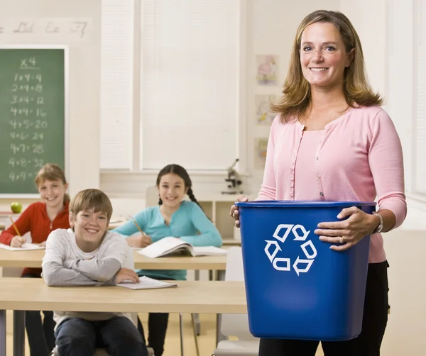 Teacher holding recycling bin — Stock Photo, Image