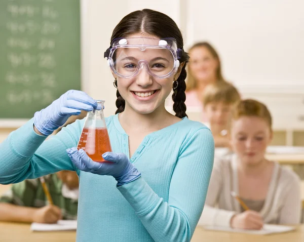 Schüler hält Becher mit Flüssigkeit im Klassenzimmer — Stockfoto