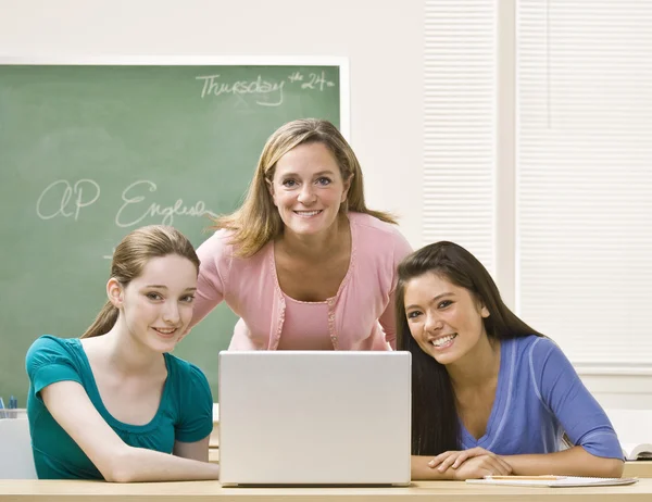 Profesor ayudando a los estudiantes en el portátil — Foto de Stock