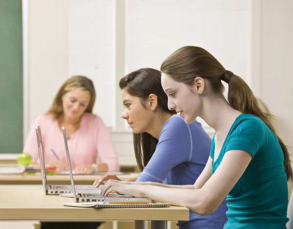 Estudiantes usando computadoras portátiles en el aula —  Fotos de Stock