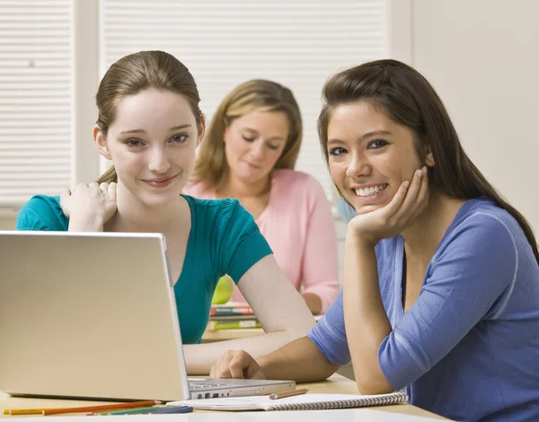 Estudiantes usando computadoras portátiles en el aula — Foto de Stock