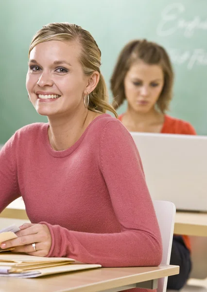 Student smiling in classroom — Stock Photo, Image