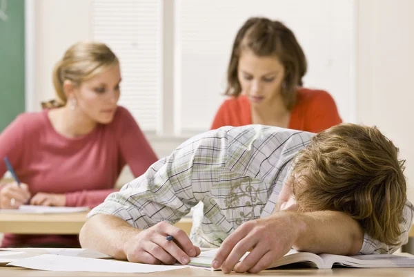 Estudiante durmiendo en el escritorio en el aula — Foto de Stock