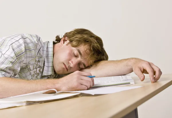 Student sleeping at desk in classroom — Stock Photo, Image