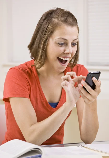 Student text messaging on cell phone in classroom — Stock Photo, Image