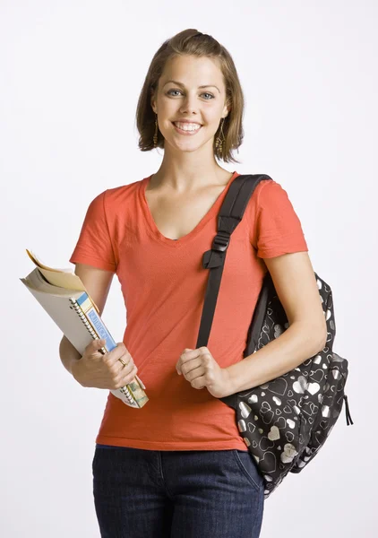 Student bär ryggsäck och böcker — Stockfoto