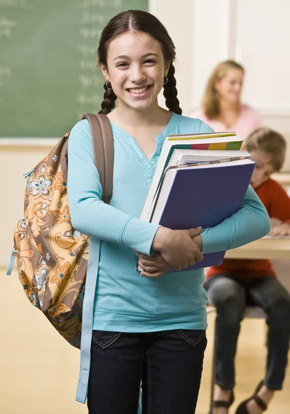 Student carrying backpack and books Stock Image