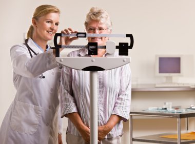 Doktor kadın kıdemli doktor ofisinde Tartım
