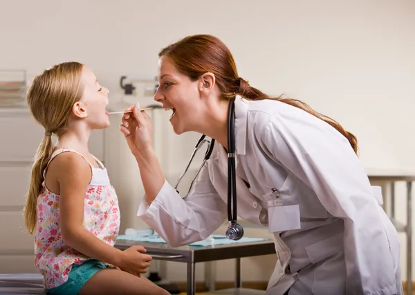 Doktor dává dívčí vyšetření v ordinaci lékaře — Stock fotografie