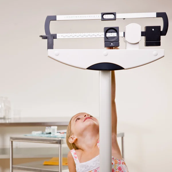 Girl weighing herself in doctor office — Stock Photo, Image