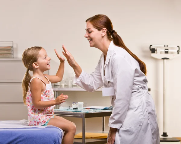 Médico dando menina alta cinco — Fotografia de Stock