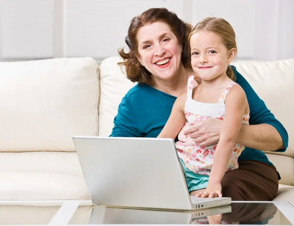 Grandmother and granddaughter using laptop — Stock Photo, Image