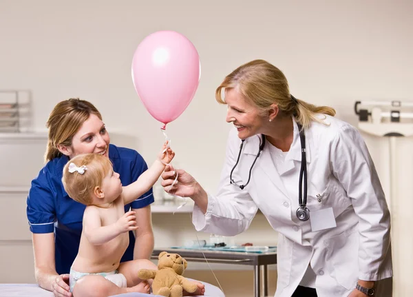 Doutor entregando balão menina bebê — Fotografia de Stock