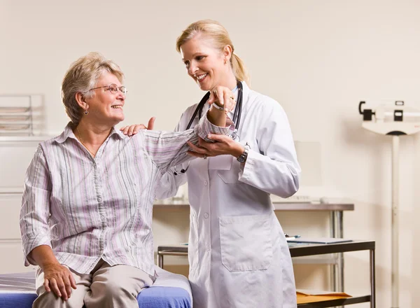 Лікар перевіряє руку старшої жінки — стокове фото