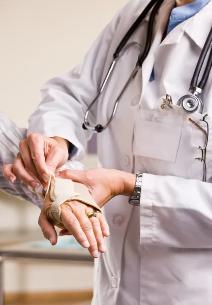 Doctor adjusting woman wrist splint — Stock Photo, Image
