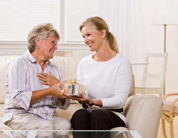 Figlia dando regalo madre — Foto Stock