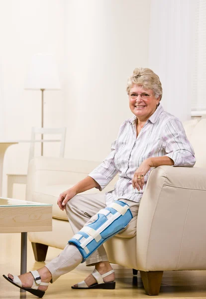 Seniorin trägt Knieschiene — Stockfoto