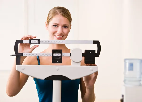 Mulher pesando-se em balanças no health club — Fotografia de Stock