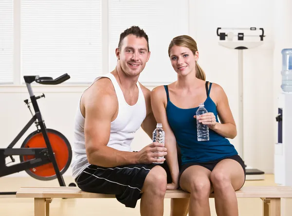 Man en vrouw drinkwater in gezondheidsclub — Stockfoto