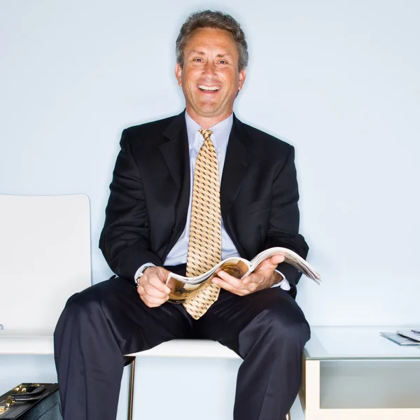 Hombre de negocios leyendo revista en sala de espera — Foto de Stock