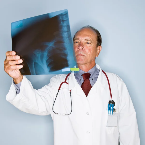 Doctor reviewing x-rays — Stockfoto