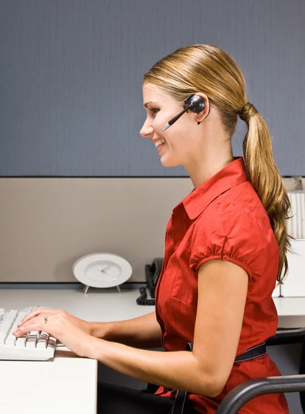Businesswoman talking on headset at desk — Stock Photo, Image