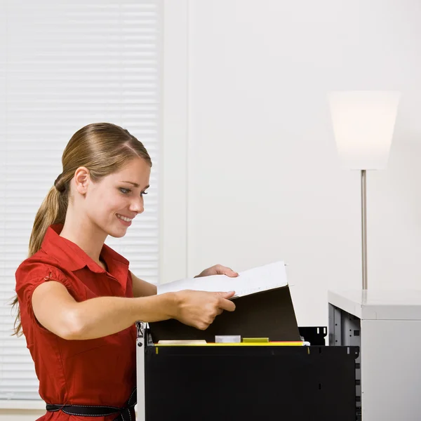 Empresaria poniendo archivo en el gabinete de archivos — Foto de Stock