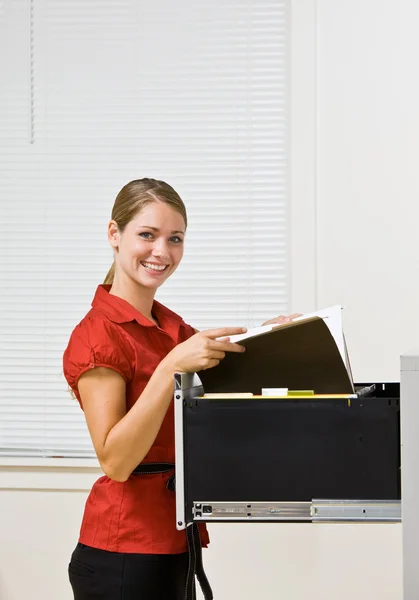 Businesswoman putting file in file cabinet — Stock Photo, Image