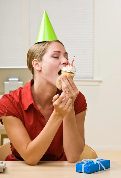 Liikenainen syö syntymäpäivä cupcake — kuvapankkivalokuva