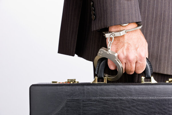 Businessman handcuffed to briefcase