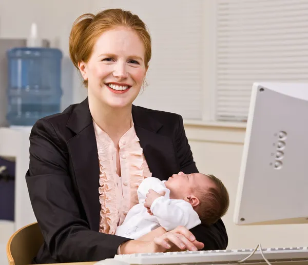 Iş kadını holding bebek masa — Stok fotoğraf