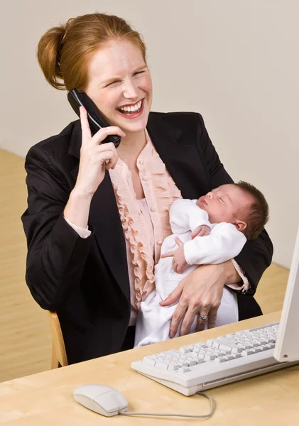 Affärskvinna anläggning baby på skrivbord — Stockfoto