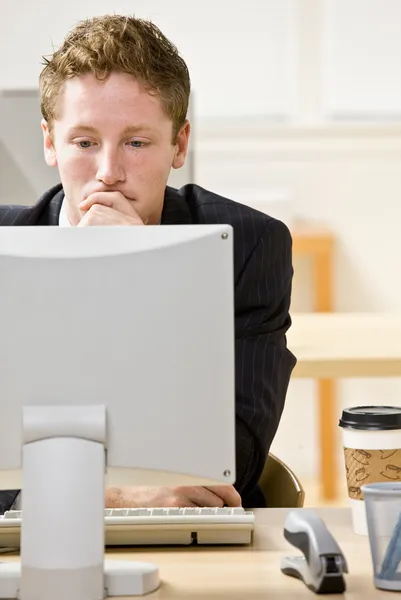 Бізнесмен дивиться за комп'ютером — стокове фото