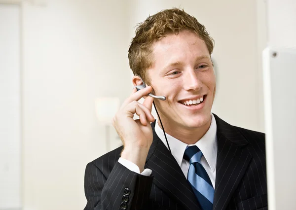 Empresário falando sobre fone de ouvido — Fotografia de Stock